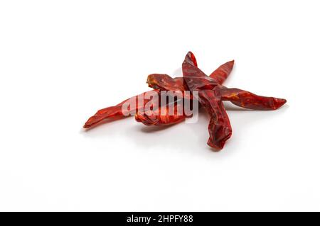 Chili séché isolé sur fond blanc, petit tas de piment rouge séché, gros plan. Banque D'Images