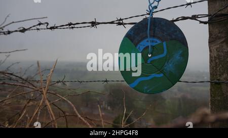 Les célibataires en vinyle, peints avec des motifs abstraits, sont exposés sur des clôtures à la campagne. Street Art. Anonyme. Derbyshire. Banque D'Images