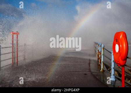 Heysham, Lancashire, Royaume-Uni. 12th févr. 2022. La lumière du soleil réfractée dans la pulvérisation forme un arc-en-ciel au-dessus de l'eau de rupture de Grosvenor à Heysham crédit: PN News/Alamy Live News Banque D'Images