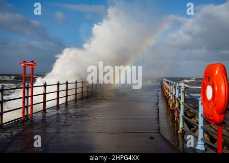 Heysham, Lancashire, Royaume-Uni. 12th févr. 2022. La lumière du soleil réfractée dans la pulvérisation forme un arc-en-ciel au-dessus de l'eau de rupture de Grosvenor à Heysham crédit: PN News/Alamy Live News Banque D'Images