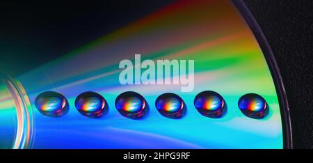 Gouttes d'eau colorées et brillantes sur l'ancien CD, design pour l'arrière-plan Banque D'Images