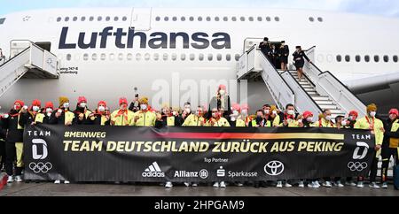 21 février 2022, Hessen, Francfort-sur-le-main : l'équipe olympique allemande se dresse derrière une affiche intitulée « Team Germany back from Beijing » lorsqu'elle revient des Jeux olympiques de Pékin à l'aéroport de Francfort. Photo: Arne Dedert/dpa Banque D'Images