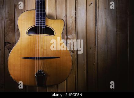 Des détails de guitare acoustique gitane jazz, pendus sur un mur en bois. Banque D'Images