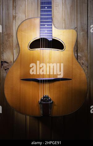 Des détails de guitare acoustique gitane jazz, pendus sur un mur en bois. Banque D'Images