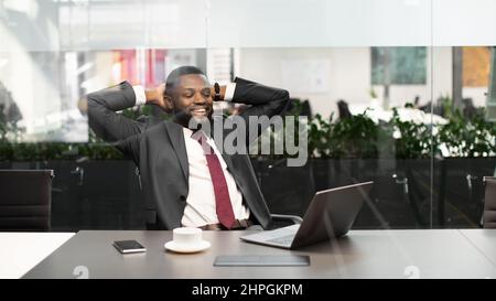 Un Manager afro-américain réussi assis devant un ordinateur portable Banque D'Images