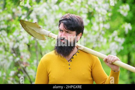 Homme barbu avec pelle de jardinage. Jardinier travaillant dans le jardin. Agriculteur se préparant à planter des plantes. Banque D'Images