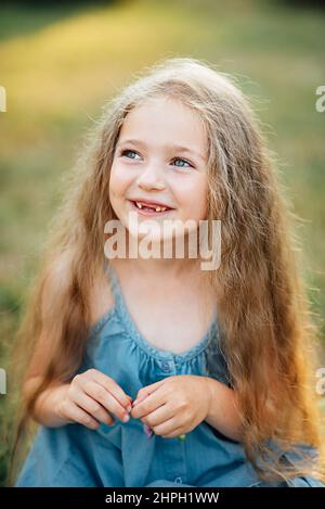 Portrait de la belle blonde joyeuse Caucasian girl smiling démontrant des dents blanches sans deux dents de devant. Enfant joyeux. Banque D'Images