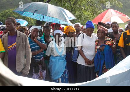 Des amis et des parents se rassemblent sous la pluie pour faire leurs adieux à feu Freddy Chiusika qui est décédé après que sa maison ait été aplatie par un glissement de terrain après quelques pluies torrentielles à Bindura, au Zimbabwe. Banque D'Images