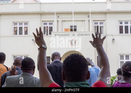 On voit une femme s'étendre les mains lors d'une réunion de prière en dehors du Parlement du Zimbabwe à Harare. La prière a été faite peu après que le président Robert Mugabe ait été renversé par un coup d'État sans effusion de sang. Zimbabwe. Banque D'Images