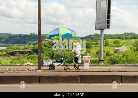 Foz do Iguaçu, Brésil - Circa janvier 2020: Homme vendant des boissons et des collations près du pont international vers le Paraguay Banque D'Images