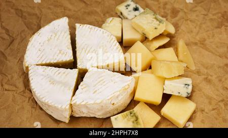 Différentes variétés de fromage. Fromage français doux de camembert et d'autres types sur papier artisanal Banque D'Images