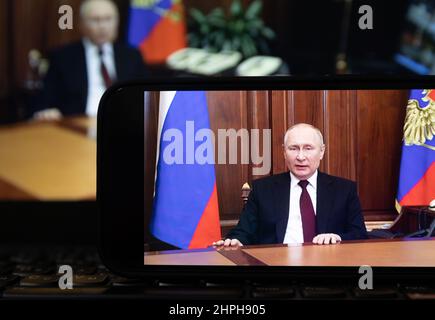 Moscou. 21st févr. 2022. Photo prise le 21 février 2022 montre un écran montrant le président russe Vladimir Poutine s'exprimant lors d'une allocution télévisée à la nation à Moscou, en Russie. Le Président russe Vladimir Poutine a annoncé lundi qu'il avait signé un décret reconnaissant la République populaire de Lugansk (LPR) et la République populaire de Donetsk (DPR) comme des États indépendants et souverains. Crédit: Bai Xueqi/Xinhua/Alay Live News Banque D'Images