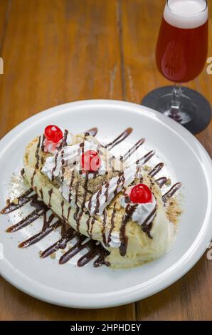 Gros plan sur un délicieux dessert à la banane et un verre de bière à la framboise Banque D'Images