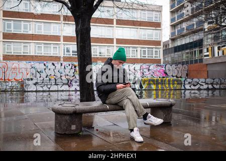 Un peu de paix et de calme sur un banc humide dans Old Street, Londres Royaume-Uni. Banque D'Images