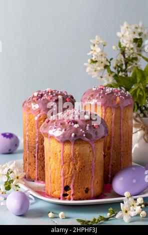 Trois gâteaux de Pâques avec œufs colorés sur fond bleu pastel. Carte de Pâques Still Banque D'Images