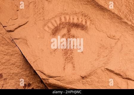 Un panneau d'art rupestre ou de pictogramme amérindien peint ancien avec une figure anthropomorphique portant une adresse fantastique. Situé sous une protection Banque D'Images