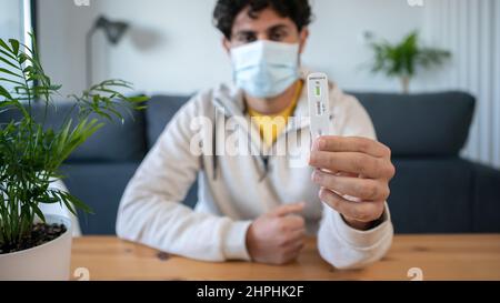 L'homme caucasien fabrique un appareil de test rapide à domicile pour le virus Covid19 avec un résultat négatif. Cassette d'antigène de test PCR express pour la nouvelle variante d'Omicron vi Banque D'Images