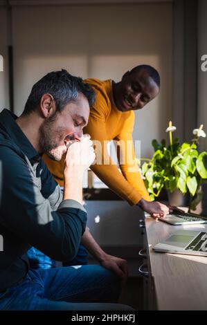 Deux collègues rient en travaillant dans un bureau. Banque D'Images