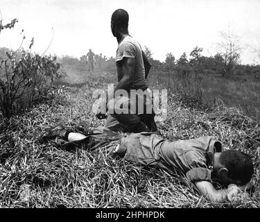 Un jeune lieutenant américain, sa jambe brûlée par un piège à phosphore blanc en explosion de Viet Cong, est traité par un médic. CA. 1966 Banque D'Images