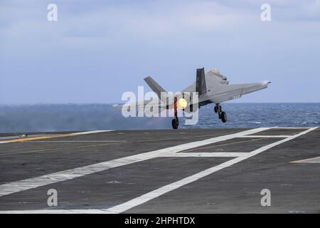 MER DES PHILIPPINES (fév 21, 2022) un F-35C Lightning II, affecté au 'Chevalier noir' de l'escadron d'attaque de chasseurs marins (VMFA) 314, sort du pont de vol du porte-avions de la classe Nimitz USS Abraham Lincoln (CVN 72). Abraham Lincoln Strike Group est en cours de déploiement prévu dans la zone d'exploitation de la flotte américaine 7th afin d'améliorer l'interopérabilité par le biais d'alliances et de partenariats tout en servant de force d'intervention prête à l'emploi pour soutenir une région Indo-Pacifique libre et ouverte. (É.-U. Photo de la marine par le Spécialiste des communications de masse 3rd classe Javier Reyes) Banque D'Images