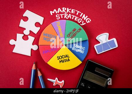 Concept de stratégie marketing. Analyse et planification, articles de bureau sur fond rouge. Banque D'Images