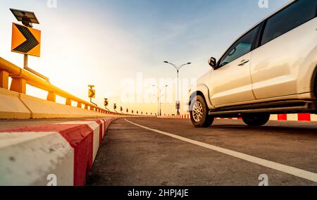 Route en béton courbe avec signalisation routière courbe et panneau rouge-blanc d'arrêt interdit. Panneau solaire énergie sur courbe signalisation routière. Voyage en voiture. Flou de mouvement Banque D'Images