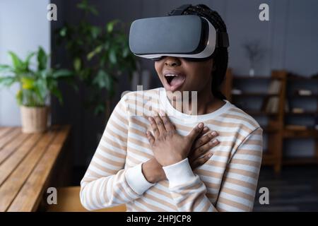 Une femme afro-américaine excitée avec la bouche largement ouvert en train de découvrir le jeu virtuel à la première fois Banque D'Images