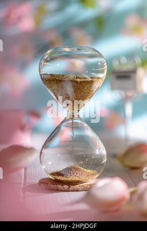 hourglass. soleil, fleurs. concept du temps, début du printemps Banque D'Images