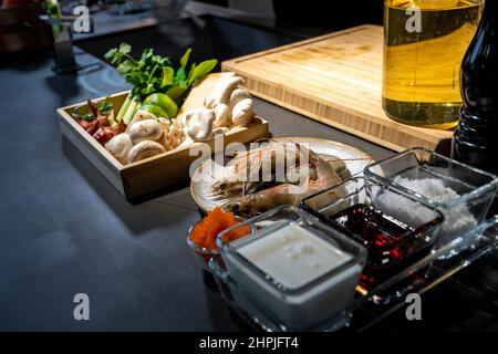 Ingrédient de cuisson, lime, champignon, échalote, citronnelle,oignon, piment, tobiko, bergamote, crevettes et fromage dans une assiette en bois.Ils sont prêts pour le méfait Banque D'Images