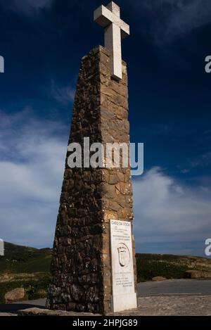 Une simple croix blanche surplombe un monument en pierre au-dessus de l'endroit au Portugal « où la terre se termine et où la mer commence » : Le promontoire sauvage et balayé par le vent de Cabo da Roca, réputé comme le point le plus à l'ouest de l'Europe continentale, avec ses spectaculaires falaises de granit et de calcaire proches de la verticale qui jôtent dans l'océan Atlantique à environ 42 km (26 miles) de la capitale portugaise, Lisbonne. Banque D'Images