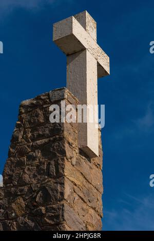 Une croix blanche surmonte un monument en pierre à l'endroit au Portugal « où la terre se termine et la mer commence » : Le promontoire sauvage et balayé par le vent de Cabo da Roca, réputé comme le point le plus à l'ouest de l'Europe continentale, avec ses spectaculaires falaises de granit et de calcaire proches de la verticale qui jôtent dans l'océan Atlantique à environ 42 km (26 miles) de la capitale portugaise, Lisbonne. Banque D'Images