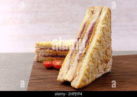 Sandwich Monte Cristo au pain avec jambon, fromage, confiture et œufs enrobés Banque D'Images