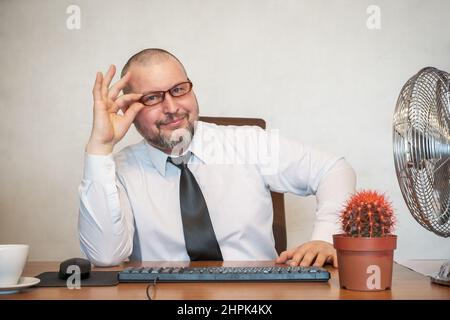 L'homme décrit comiquement le travail d'un homme d'affaires. Il montre le contentement et la joie sur son visage et sa posture. Banque D'Images