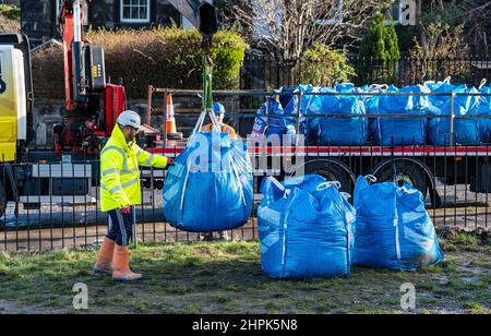 Trinity Primary School, Édimbourg, Écosse, Royaume-Uni, 22 février 2022. Terre végétale pour les écoles : excavation pendant le projet de biomes du jardin botanique royal, un surplus de terre végétale de 50 tonnes est accordé aux écoles, aux allotissements et aux organismes communautaires par la société de construction Balfour Beatty. Une livraison de 5 tonnes a lieu à l'école primaire Trinity pour transporter la terre ou la terre pour remplir les planteurs dans le jardin de l'école pour que les élèves cultivent des légumes. Les élèves du primaire 4 utilisent des récipients de toutes formes et tailles pour déplacer la terre pour remplir les planteurs ; un travail d'équipe est nécessaire Banque D'Images