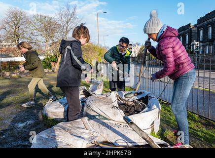 Trinity Primary School, Édimbourg, Écosse, Royaume-Uni, 22 février 2022. Terre végétale pour les écoles : excavation pendant le projet des biomes du jardin botanique royal, un surplus de terre végétale de 50 tonnes est accordé aux écoles, aux allotissements et aux organismes communautaires par Balfour Beatty. Une livraison de 5 tonnes a lieu à l'école primaire Trinity pour transporter la terre ou la terre pour remplir les planteurs dans le jardin de l'école pour que les élèves cultivent des légumes. Les élèves du primaire 4 utilisent des récipients de toutes formes et tailles pour déplacer la terre pour remplir les planteurs ; un travail d'équipe est nécessaire Banque D'Images