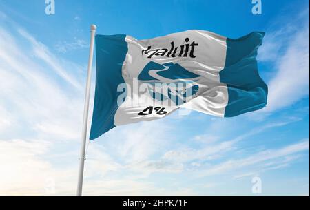 Drapeau d'Iqaluit, Nunavut , Canada à ciel nuageux sur fond de coucher de soleil, vue panoramique.Concept de voyage et de patriote canadien. Espace de copie pour bannière large. Banque D'Images