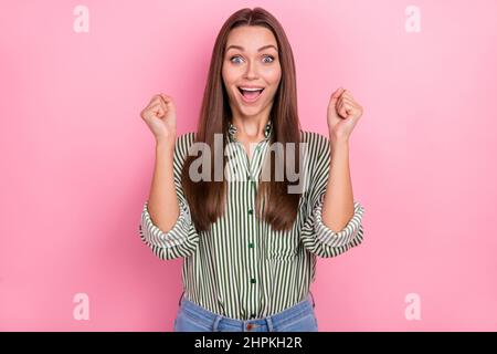 Photo d'une dame excitée et stupéfait lever les mains pour célébrer la victoire porter une chemise rayée verte isolée couleur rose fond Banque D'Images