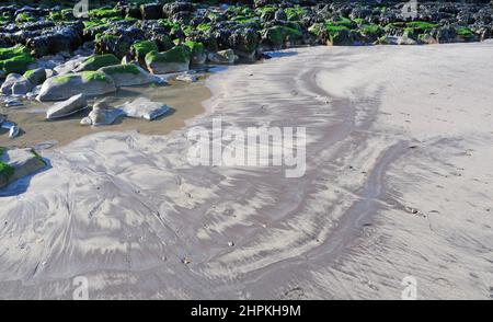 Piscines de sable et de roche de différentes couleurs, Whitby Beach, Yorkshire. Banque D'Images