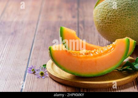 tranché de melons japonais, de melon de miel ou de cantaloup (Cucumis melo) sur fond de table en bois.fruit préféré en été. Concept de santé. Banque D'Images