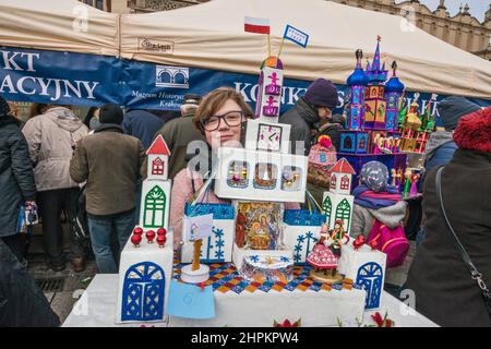 Fille portant la scène de la nativité de Szopka à exposer pendant le concours annuel de décembre, événement inclus dans la liste du patrimoine culturel de l'UNESCO, au monument Adam Mickiewicz, place du marché principal, Cracovie, Pologne Banque D'Images