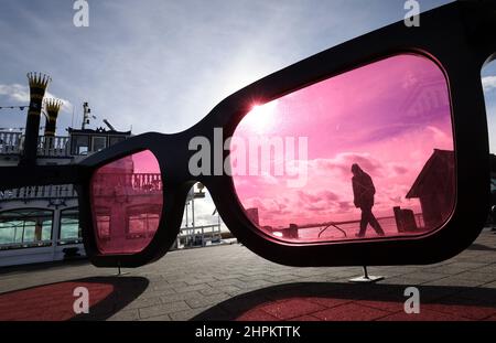 Zingst, Allemagne. 22nd févr. 2022. Dans le port de Bodden de la station balnéaire Baltique, les grands verres roses 'sea Pink II' de Marc Moser, sculpteur suisse, brillent au soleil. Après des jours de pluie et de temps orageux, le soleil et le ciel bleu sont visibles dans le nord. Credit: Bernd Wüstneck/dpa-Zentralbild/dpa/Alay Live News Banque D'Images