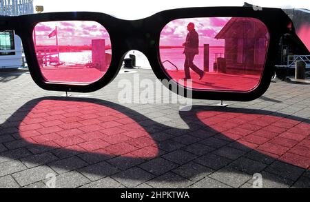 Zingst, Allemagne. 22nd févr. 2022. Dans le port de Bodden de la station balnéaire Baltique, les grands verres roses 'sea Pink II' de Marc Moser, sculpteur suisse, brillent au soleil. Après des jours de pluie et de temps orageux, le soleil et le ciel bleu sont visibles dans le nord. Credit: Bernd Wüstneck/dpa-Zentralbild/dpa/Alay Live News Banque D'Images