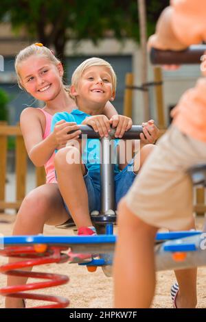 Les enfants gaies sont en train de teetering sur l'oscillation Banque D'Images