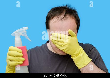 Pleurs homme propre en gants jaunes, portrait sur fond bleu studio Banque D'Images