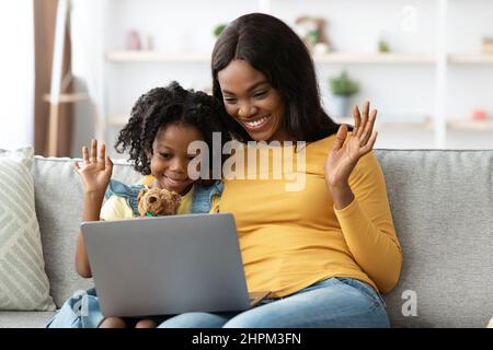 Maman noire et enfant féminin effectuant des appels vidéo avec un ordinateur portable à la maison Banque D'Images