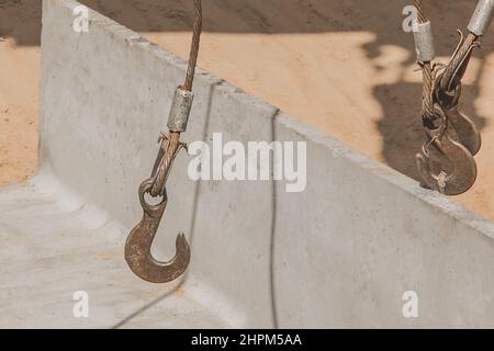 Mécanisme de levage à crochet en fer lourd avec un câble en acier avec une structure en béton et en ciment sur les chantiers de construction. Banque D'Images