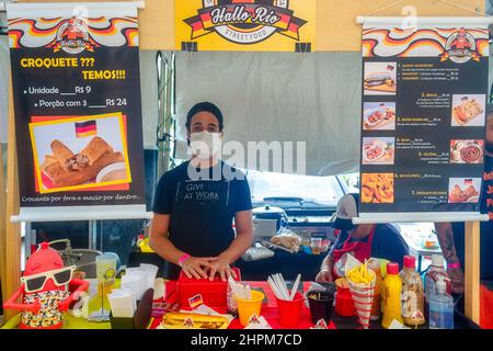 Jeune homme avec masque dans le kiosque de Hallo Rio Street Food vu dans la foire traditionnelle dans le Cinéma Reserva Cultural Nitreói. L'événement showc Banque D'Images