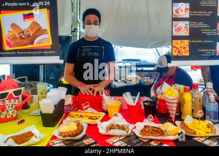 Jeune homme avec masque dans le kiosque de Hallo Rio Street Food vu dans la foire traditionnelle dans le Cinéma Reserva Cultural Nitreói. L'événement showc Banque D'Images