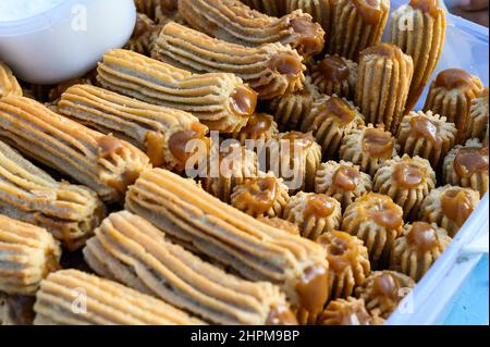 Des churros péruviens empilés sur une boîte en plastique Banque D'Images