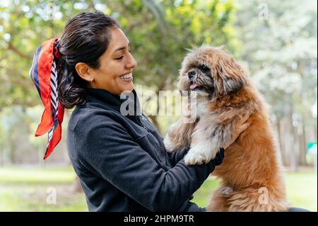 Adorable chiot aux bras de son maître aimant. Petit chien adorable avec fourrure rigole drôle avec femme adulte Banque D'Images